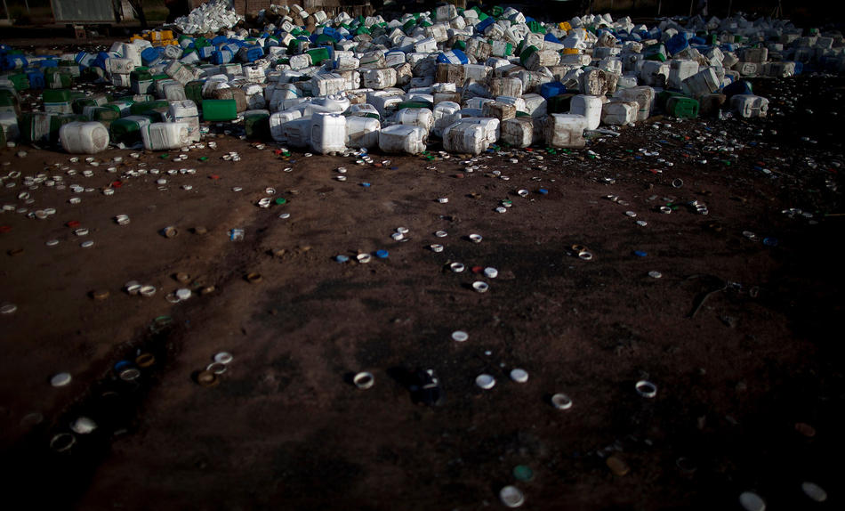 In this May 2, 2013 photo, empty agrochemical containers including Monsanto’s Round Up products lay discarded at a recycling center in Quimili, Santiago del Estero province, Argentina. Instead of a lighter chemical burden in Argentina, agrochemical spraying has increased eightfold, from 9 million gallons in 1990 to 84 million gallons today. Glyphosate, the key ingredient in Monsanto’s Round Up products, is used roughly eight to ten times more per acre than in the United States. Yet Argentina doesn’t apply national standards for farm chemicals, leaving rule-making to the provinces and enforcement to the municipalities. The result is a hodgepodge of widely ignored regulations that leave people dangerously exposed. (AP Photo/Natacha Pisarenko)