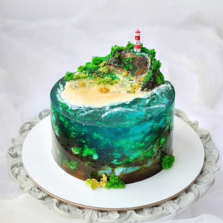 Creative marine and ocean theme cake made with jelly, featuring a cute lighthouse on top of an island hill.